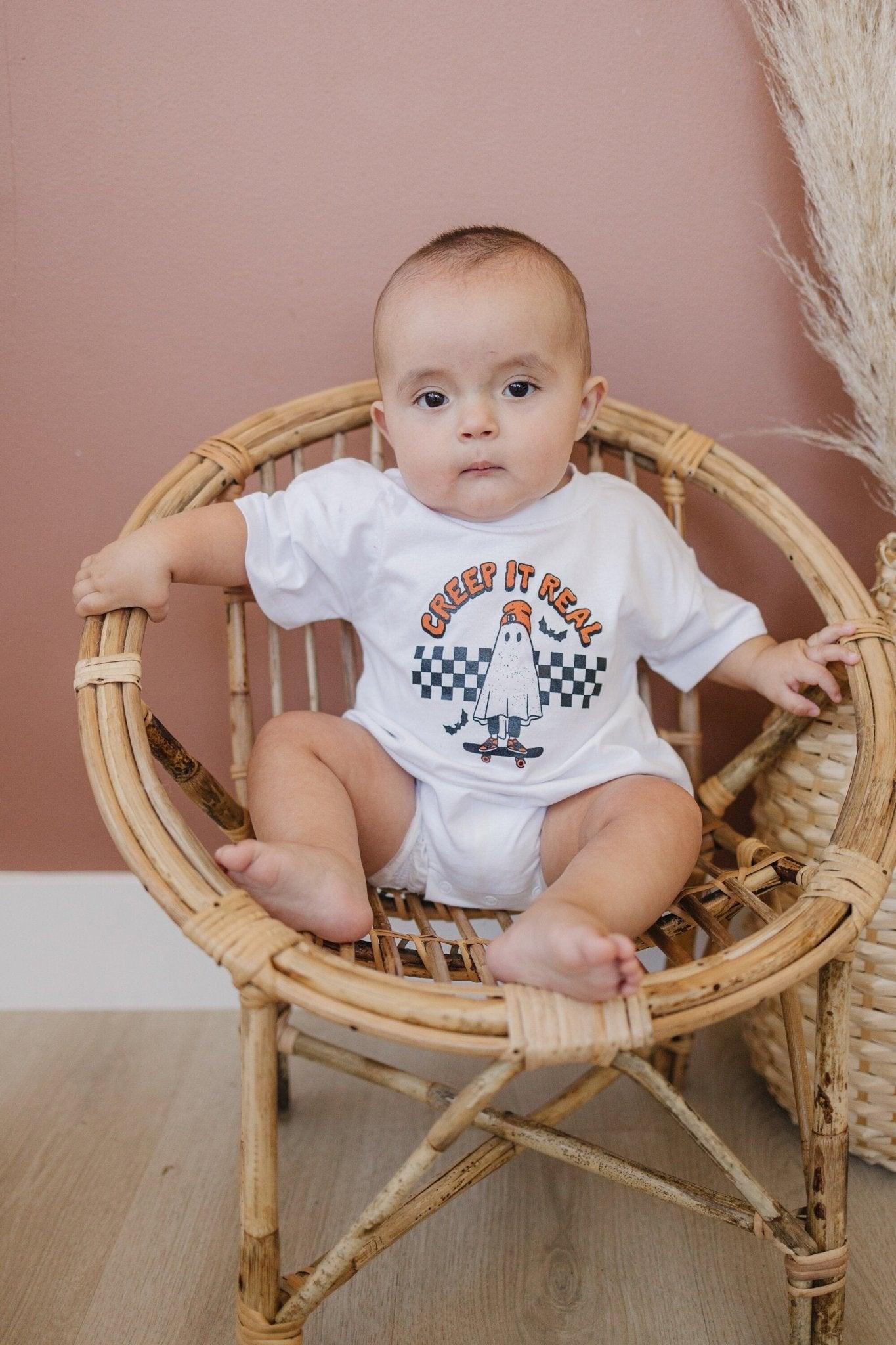 Organic cotton baby romper with a screenprinted "Creep It Real" Halloween graphic on the front.