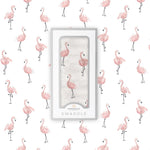 Baby wrapped in a white Newcastle Classics muslin swaddle with a vibrant dancing flamingo pattern.