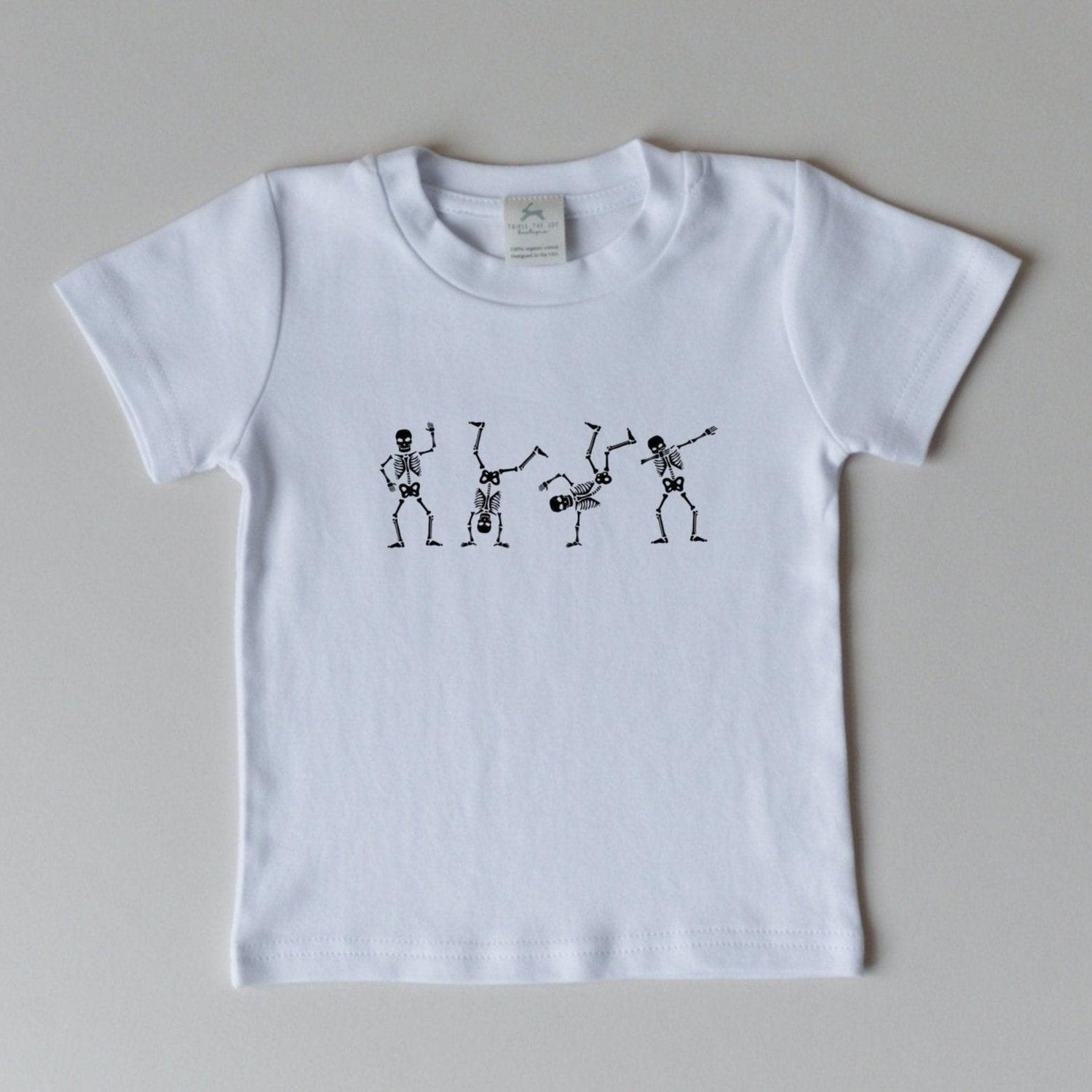 Organic cotton Halloween tee with a screenprinted dancing skeletons graphic on the front.