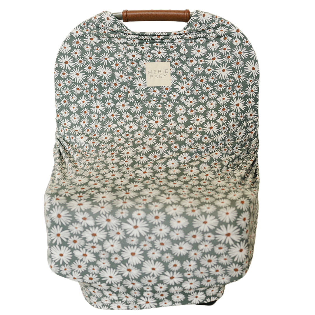 Multi-use baby cover in dark green with a white daisy pattern, draped to show its soft bamboo fabric
