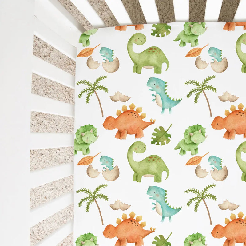 Fitted crib sheet with colorful dinosaur pattern in a standard crib.