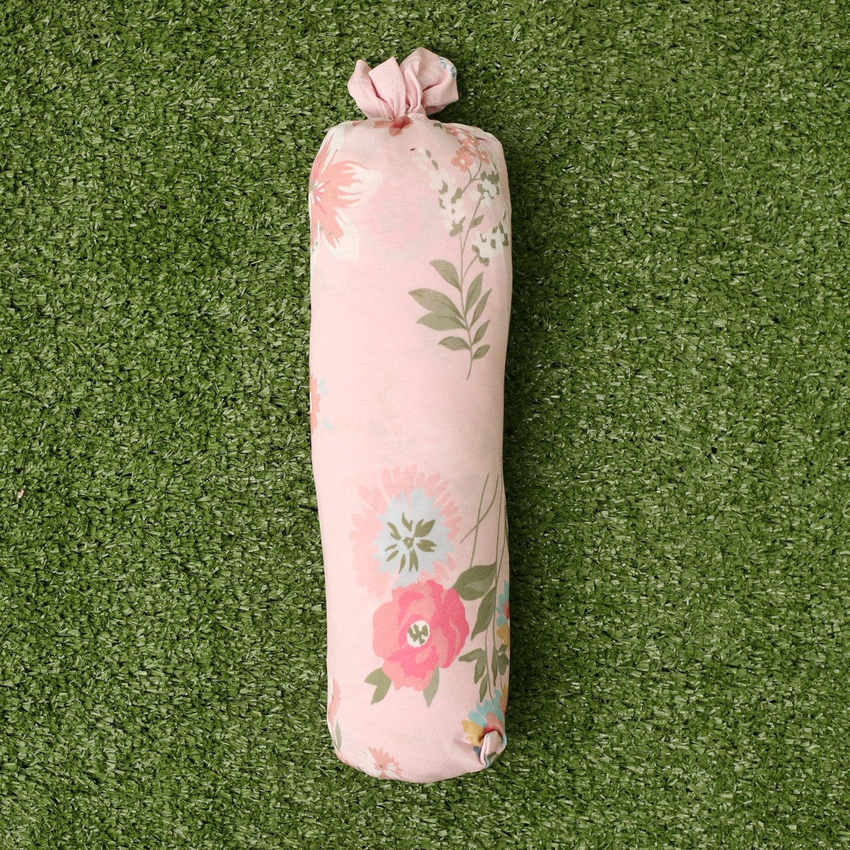 Baby swaddle blanket in a pink ditzy floral print, spread flat to show the small rose pattern.