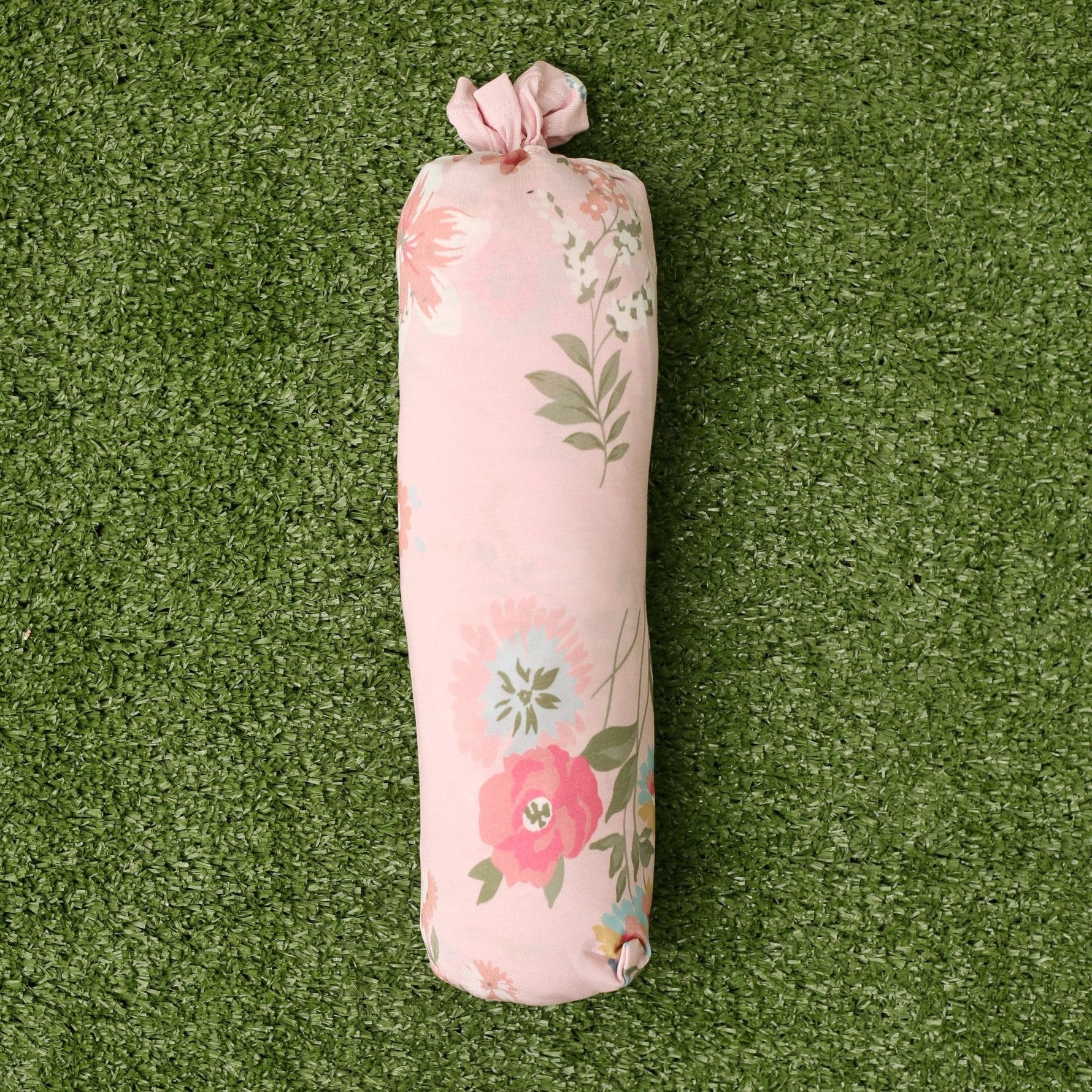 Baby swaddle blanket in a pink ditzy floral print, spread flat to show the small rose pattern.