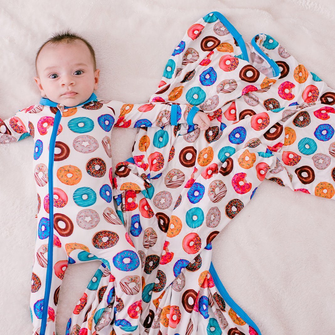 Swaddle blanket with a donut print pattern, spread flat to show its square shape