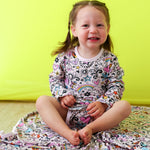 Doodle Days bodysuit dress with long sleeves and a hand-drawn doodle print, shown in pink tones.