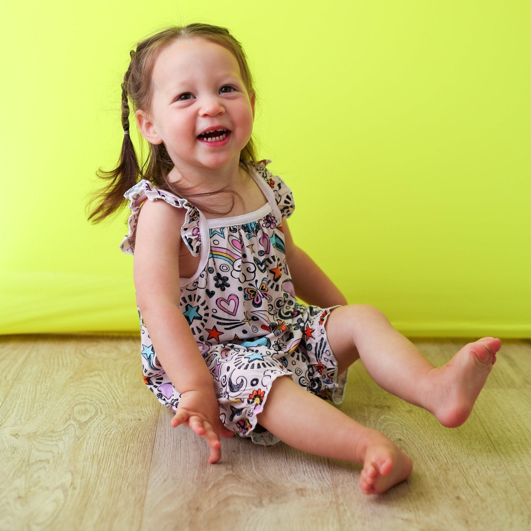 Bubble romper with a playful doodle print, flutter sleeves, and snaps along the legs