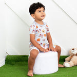 Baby short-sleeve pajama set with shorts in a dreamy dog print, worn by a smiling toddler