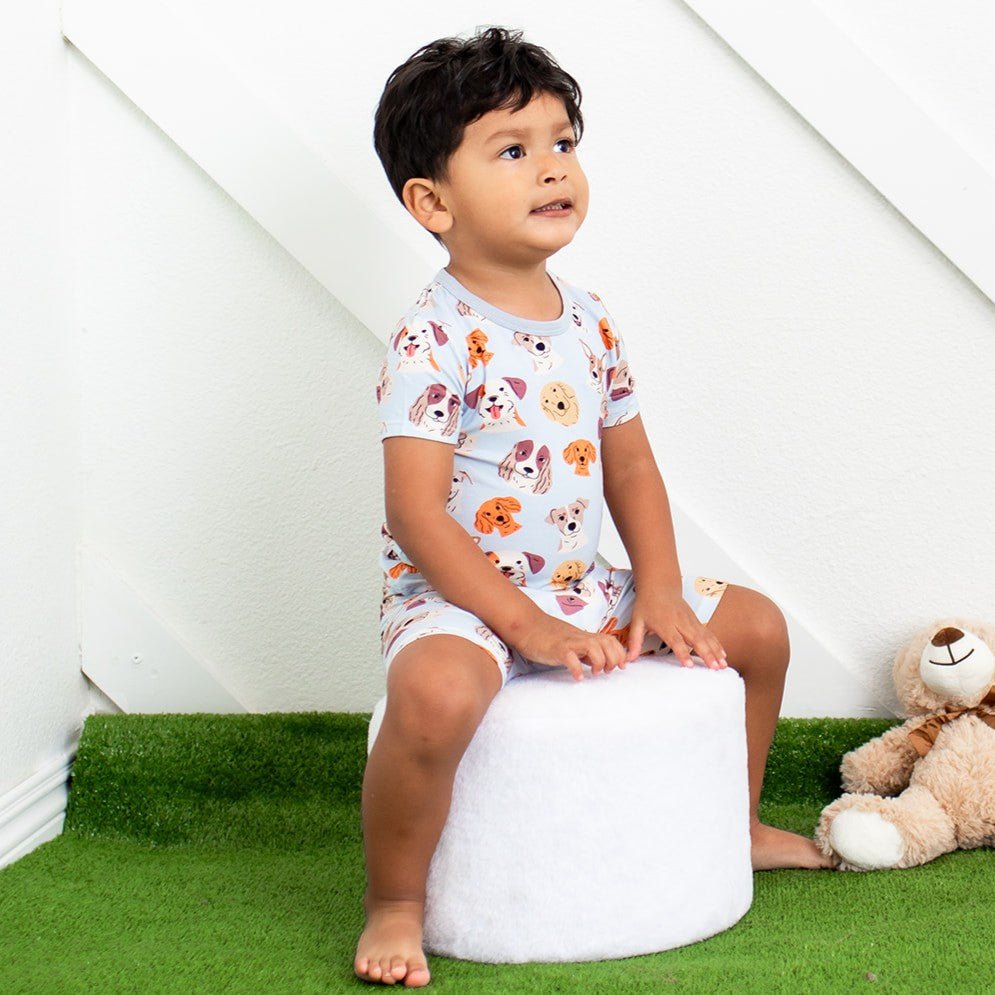 Baby short-sleeve pajama set with shorts in a dreamy dog print, worn by a smiling toddler