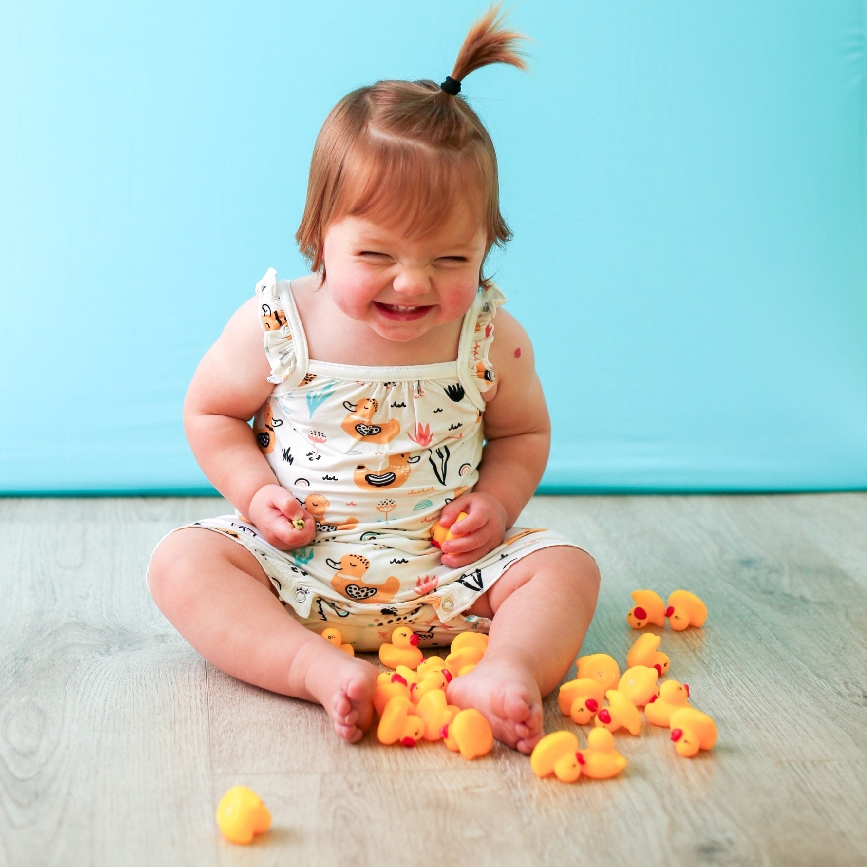 Bubble romper with flutter sleeves in a duck print, snaps along the legs for diaper changes.