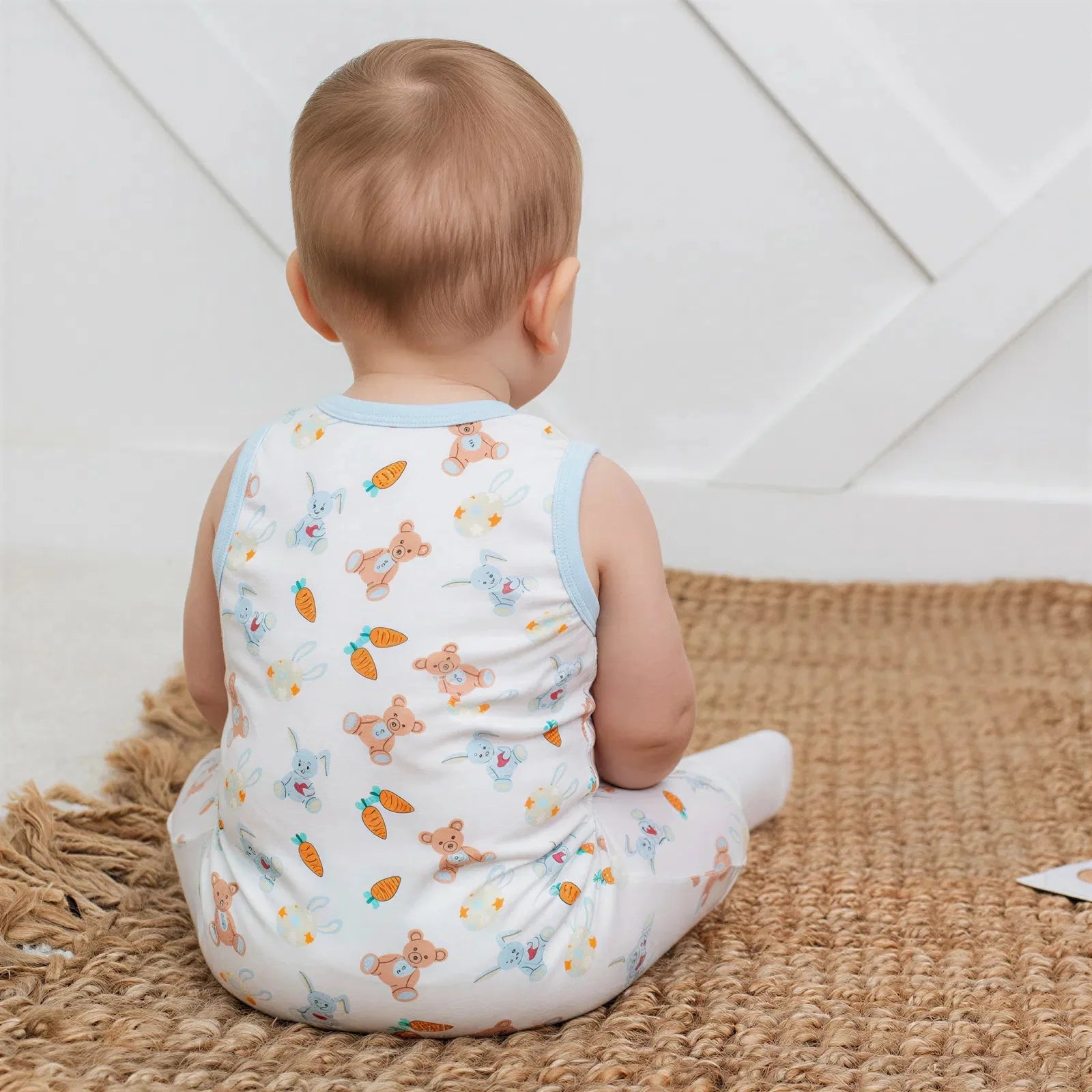 Sleeveless baby shortall with a carrot print, shoulder snaps, and snap closures along the legs.