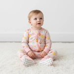 Baby footie pajamas in a pink Easter egg parade print with long sleeves and covered feet