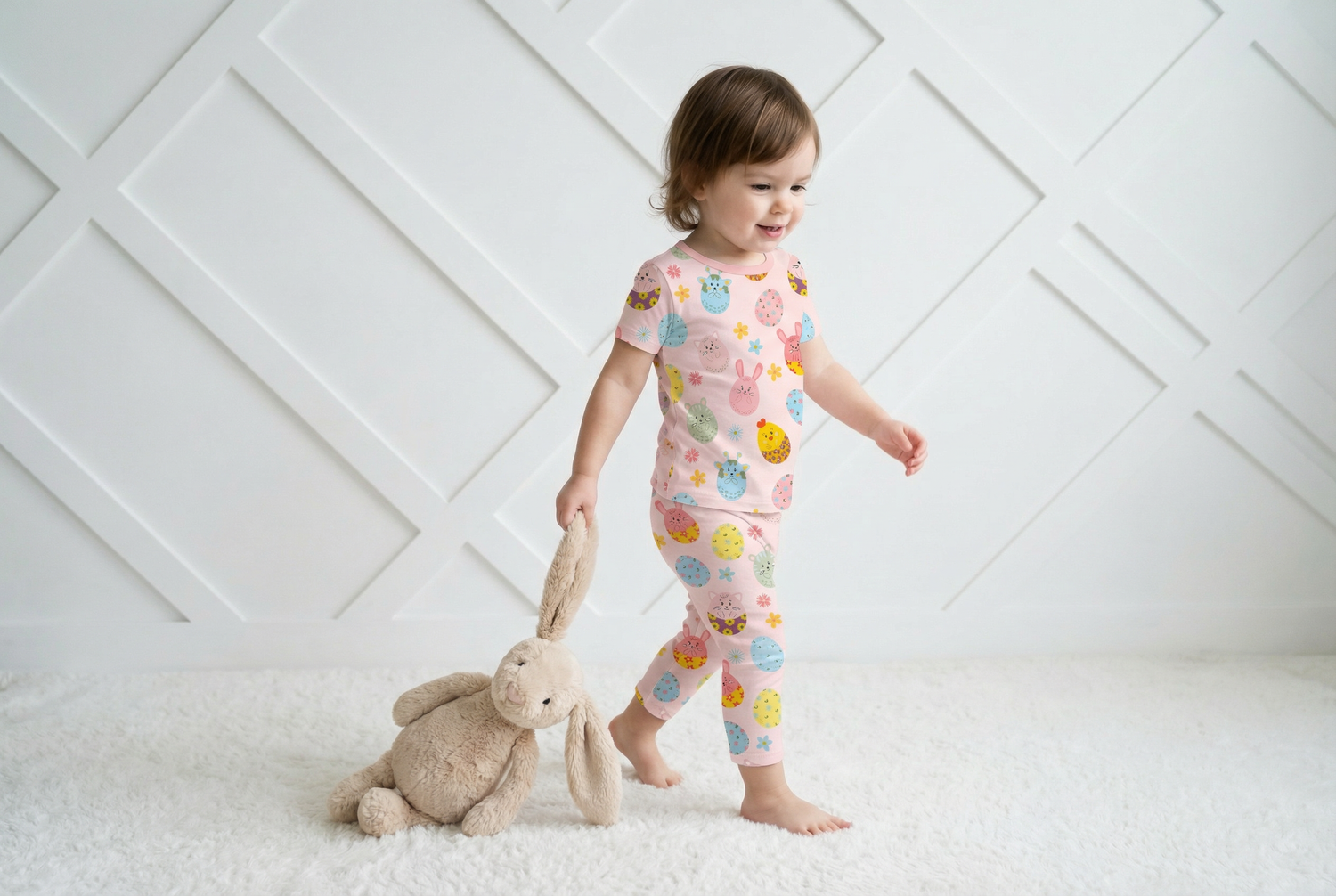 Two-piece short sleeve pajama set with a colorful Easter egg parade print on top and shorts