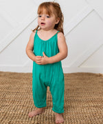 Emerald green toddler jumpsuit with pockets, worn by a barefoot child