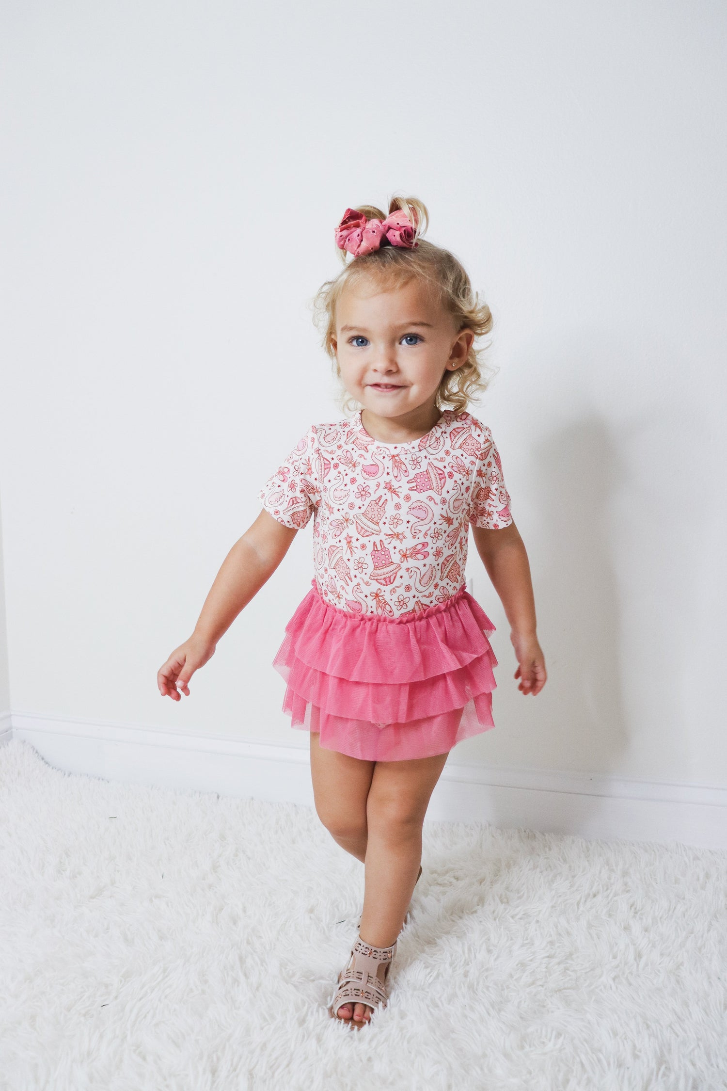Short-sleeve baby bodysuit dress with an attached tutu skirt and ballet theme.