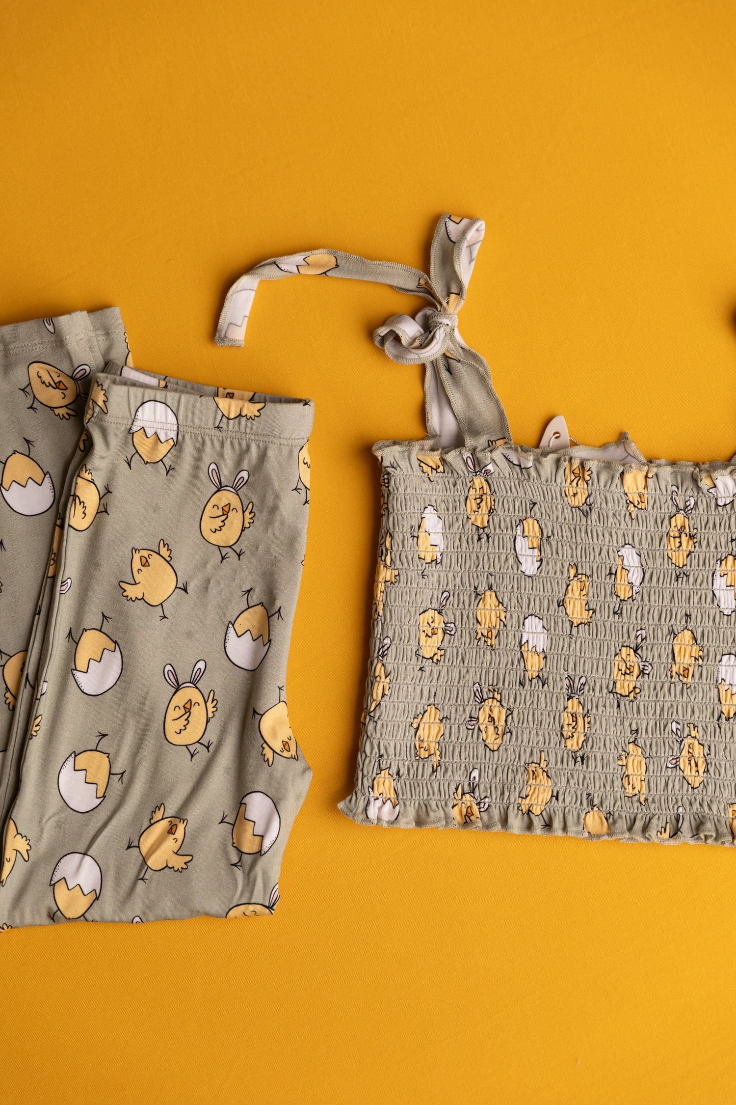 Two-piece baby girl set with a smocked top and flared bottoms in a chick-print spring pattern.