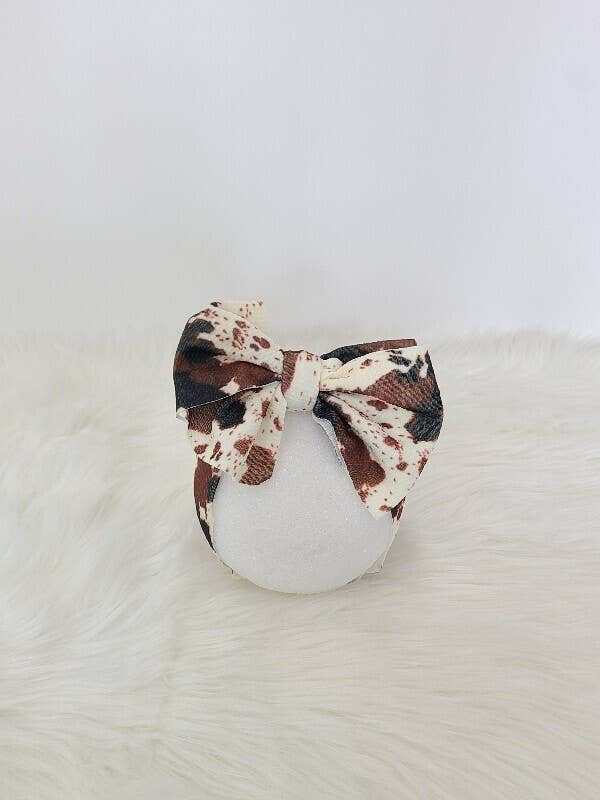 Clover Cottage cowhide waffle baby headband with knot design on soft fabric.
