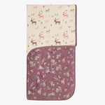 Mauve swaddle blanket printed with fall florals and winter deer, shown spread open.