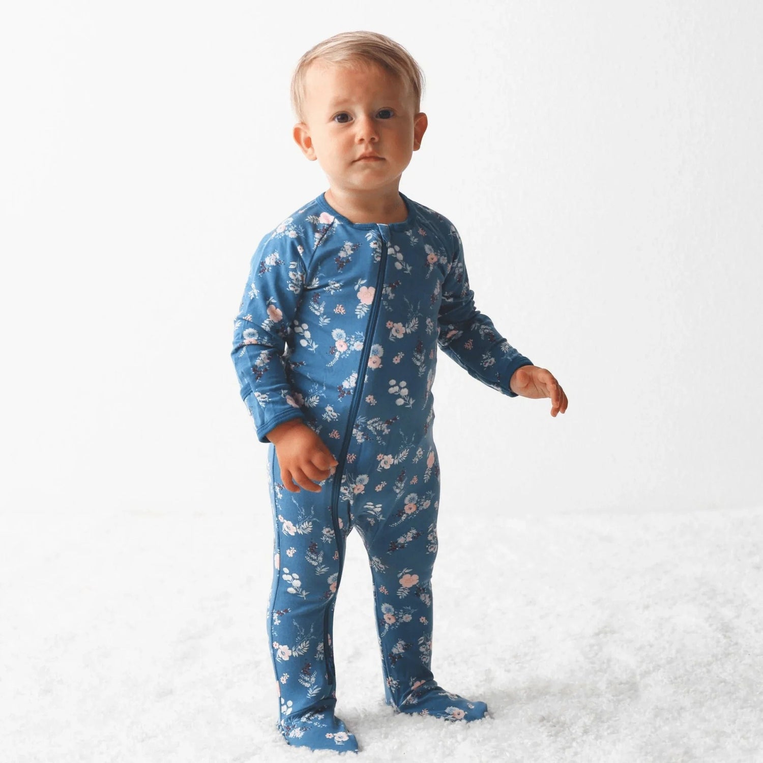 Navy baby footie pajamas printed with fall florals, with a full-length zipper and covered feet.