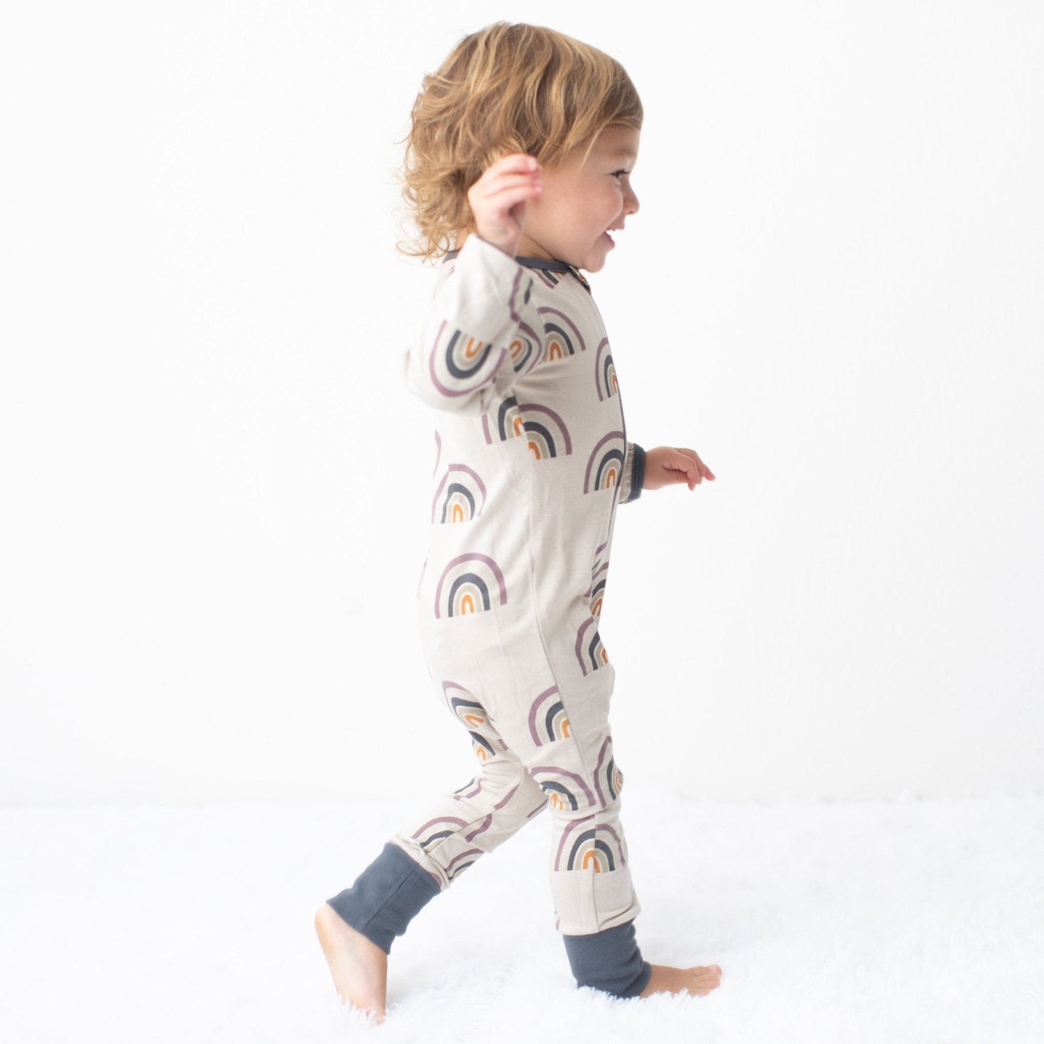 Baby coverall in a warm fall rainbow pattern with a full-length zipper and cuffed ankles
