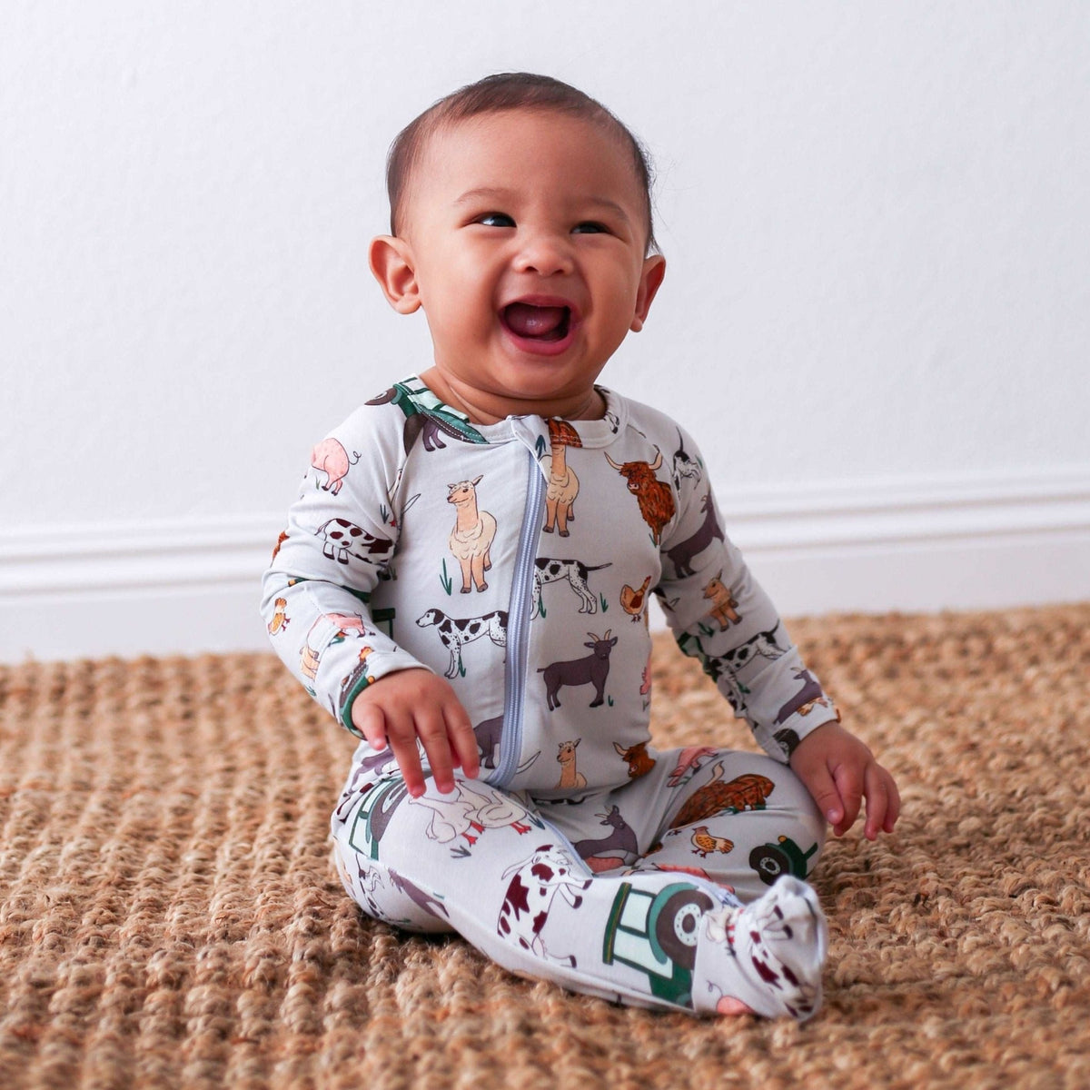 Baby footie pajamas with a farm-themed print, full-length zipper, and covered feet