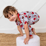 Baby coverall in a whimsical fastball baseball print with footed legs and a full-length front zipper
