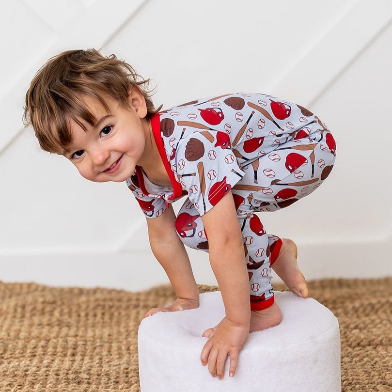 Baby coverall in a whimsical fastball baseball print with footed legs and a full-length front zipper