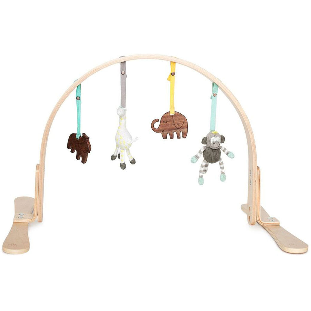 Birch wood baby play gym with an arched frame and hanging wooden toys and knit dolls