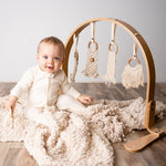 Modern Nursery natural wooden baby play gym with organic hanging toys.