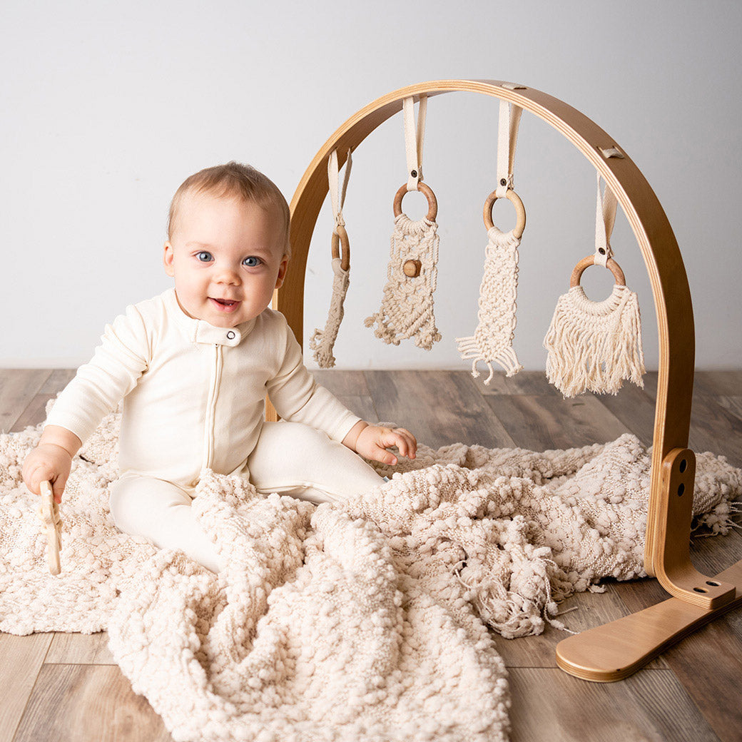Modern Nursery natural wooden baby play gym with organic hanging toys.