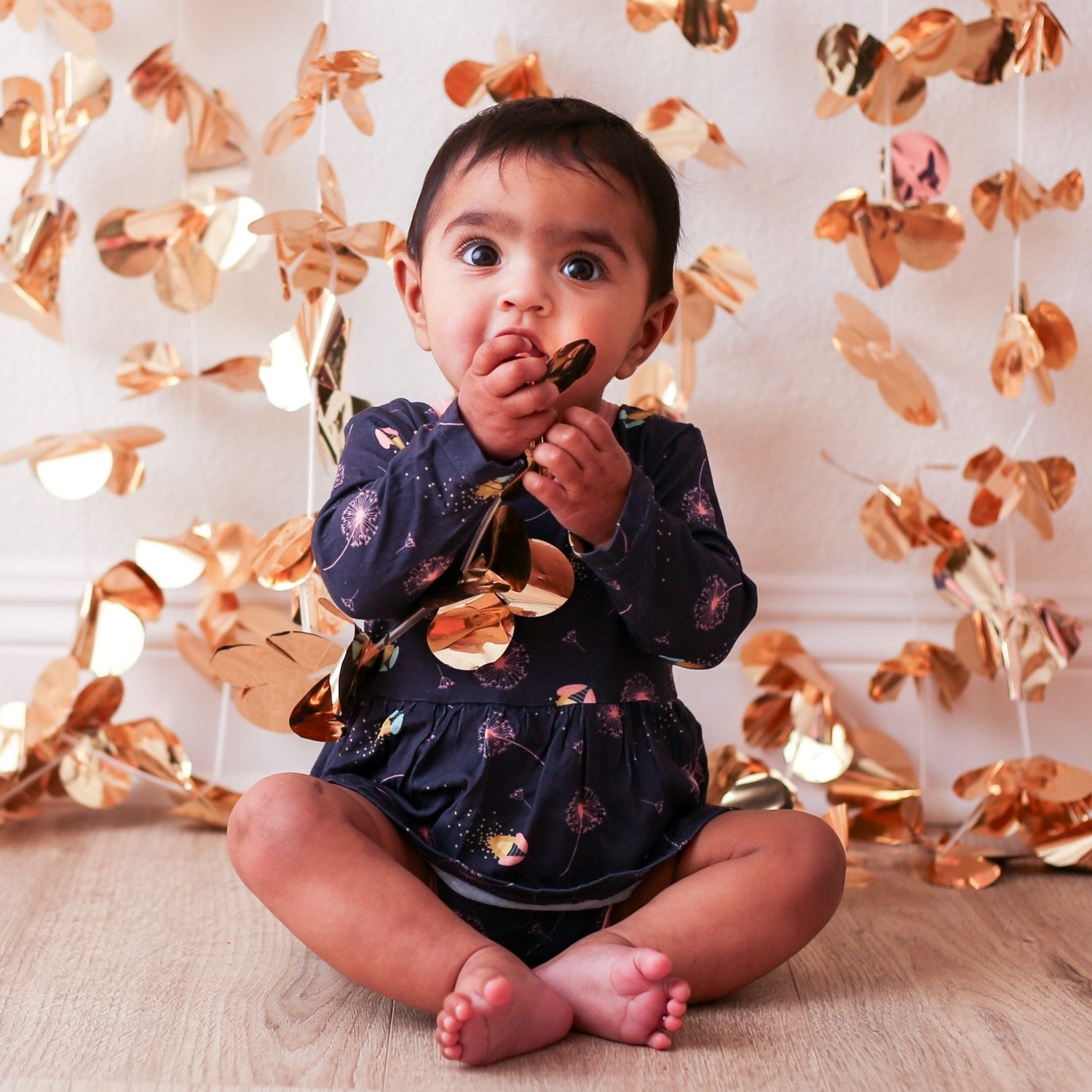 Baby bodysuit dress with a fireflies print, long sleeves, and a snap closure at the inseam