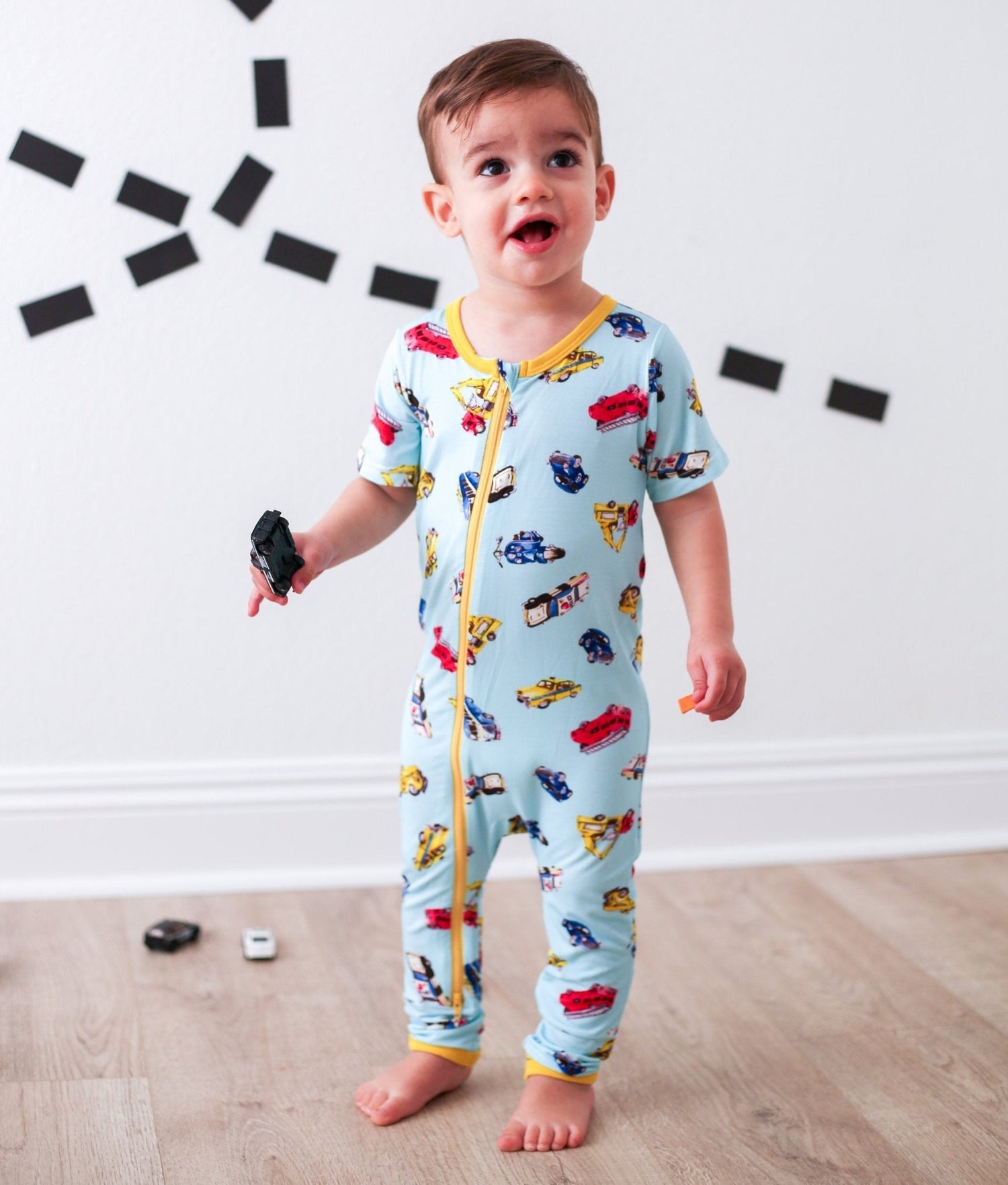 Short sleeve baby coverall with front dual zipper and cuffed ankles in a first responder print