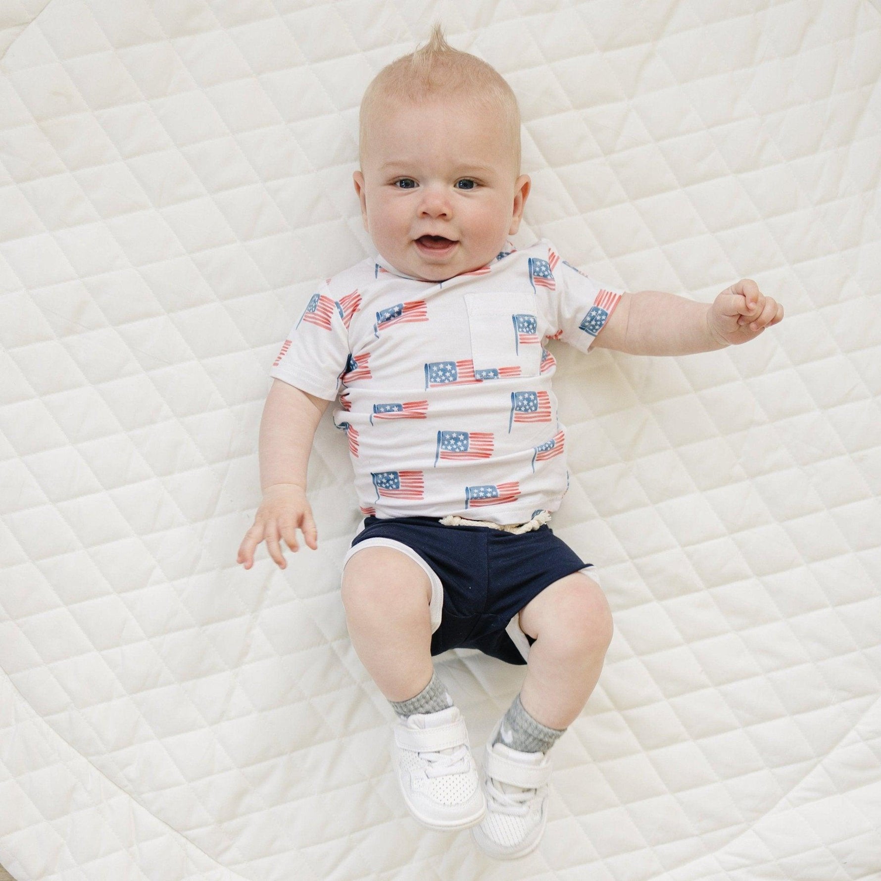 Baby wearing Little Joy Co bamboo flag print pocket tee and matching shorts set