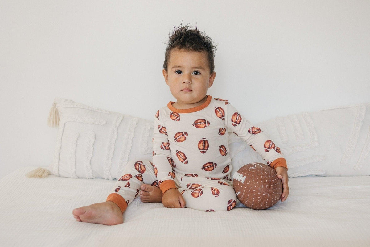 Two-piece baby pajama set with football print, long sleeve top and matching pants