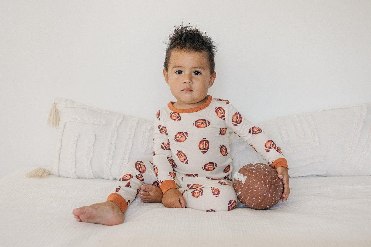Two-piece baby pajama set with football print, long sleeve top and matching pants