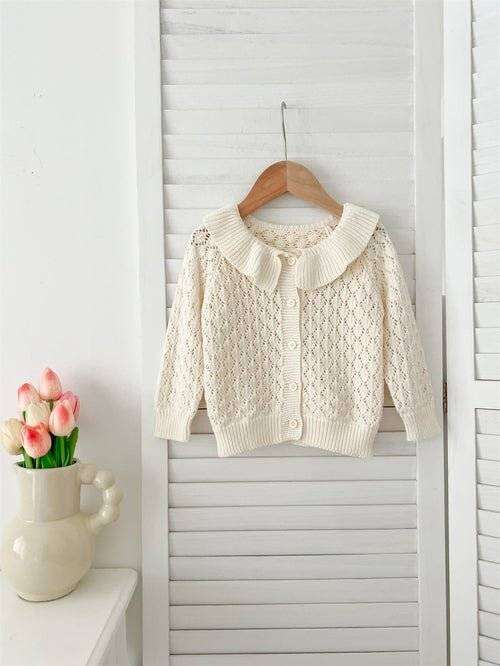  Girls Comfortable Sweater-out geometric sweater hanging on wooden hanger.