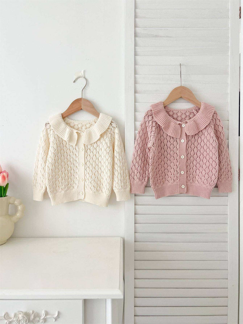  Girls Comfortable Sweater-out geometric sweaters in cream and pink hanging on wooden hangers.