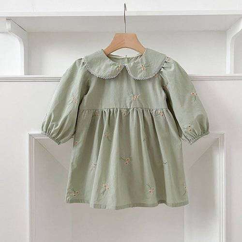 Girls green long sleeves top with daisy floral embroidery on a hanger.