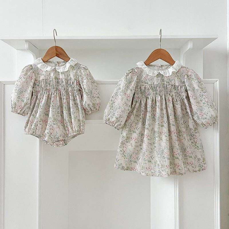 Girls long sleeves floral dress with elegant design hanging on wooden hangers.