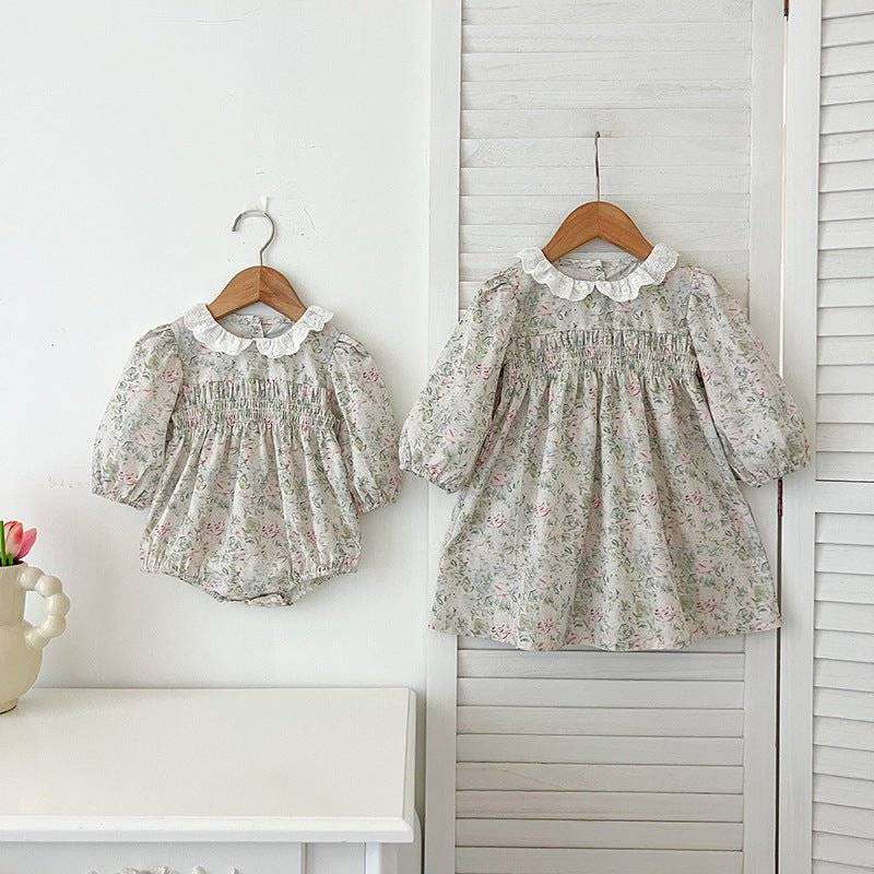 Girls long sleeves floral dress with elegant design hanging on a wooden hanger.