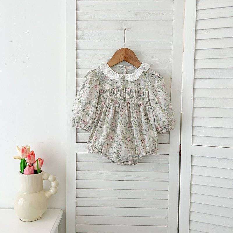 Girls long sleeves floral dress hanging on a wooden hanger.