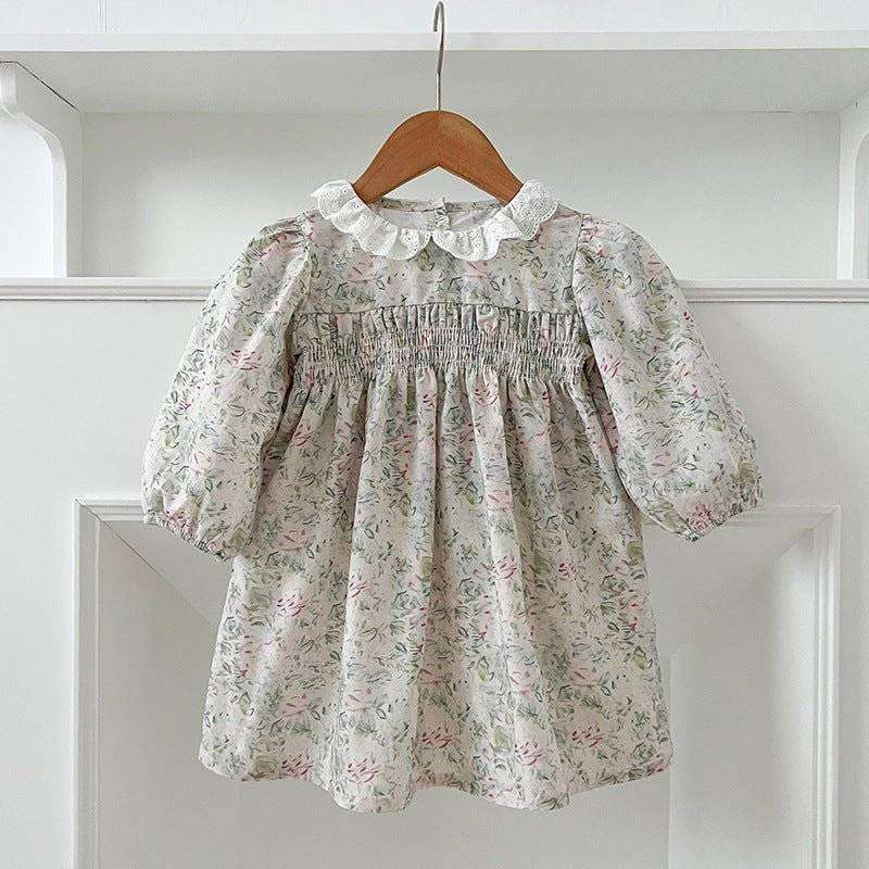 Girls long sleeves floral dress with elegant pattern hung on wooden hanger.