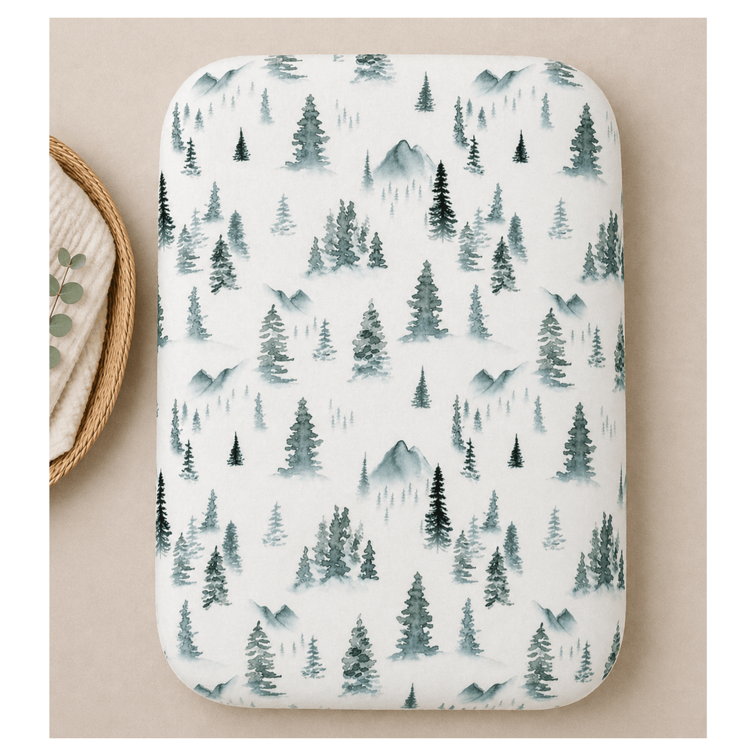Soft organic bamboo changing pad cover in a green forest print, draped over a changing pad.