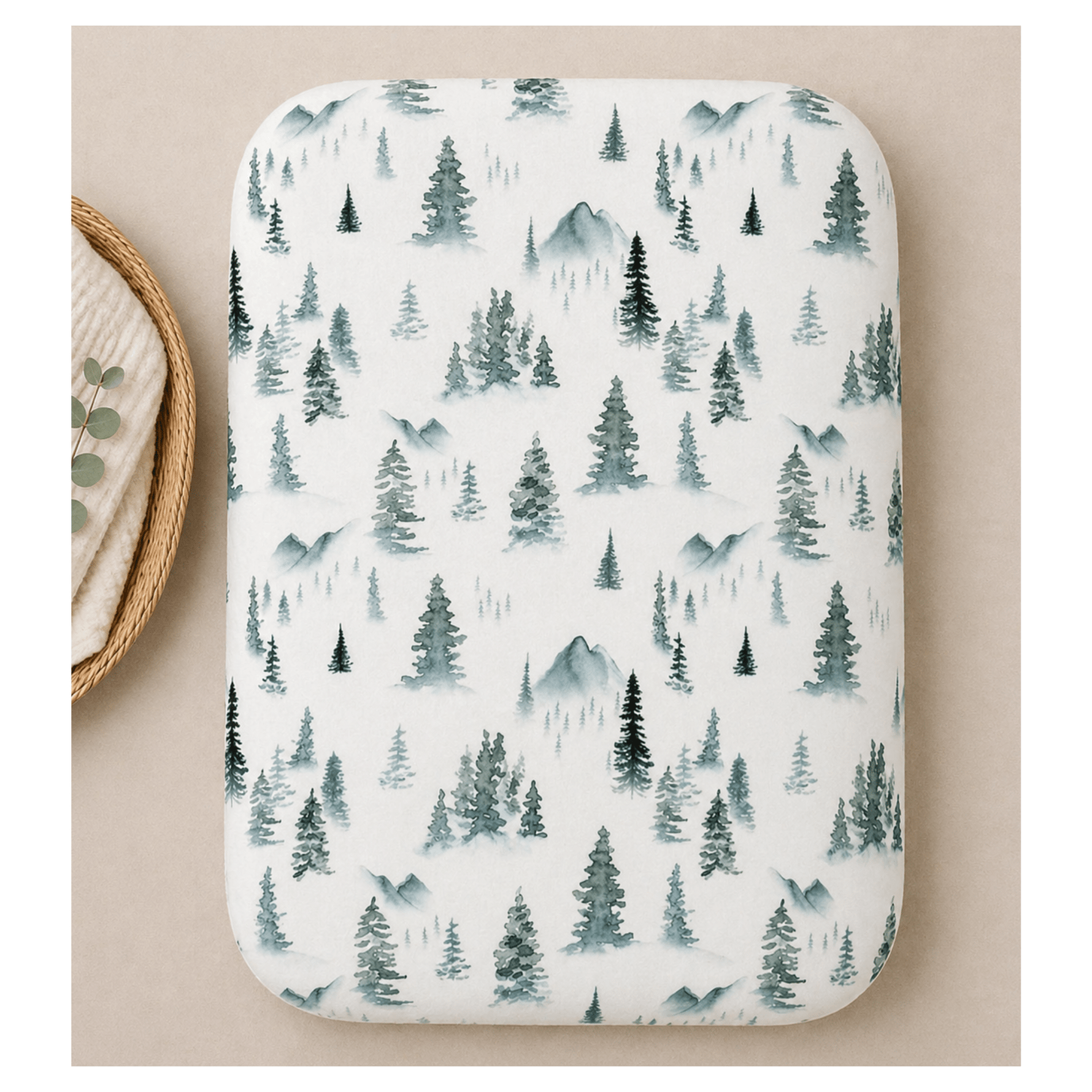 Soft organic bamboo changing pad cover in a green forest print, draped over a changing pad.