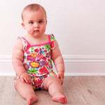 Bubble romper with a groovy floral bloom print in pink, featuring flutter sleeves and snaps along the legs.