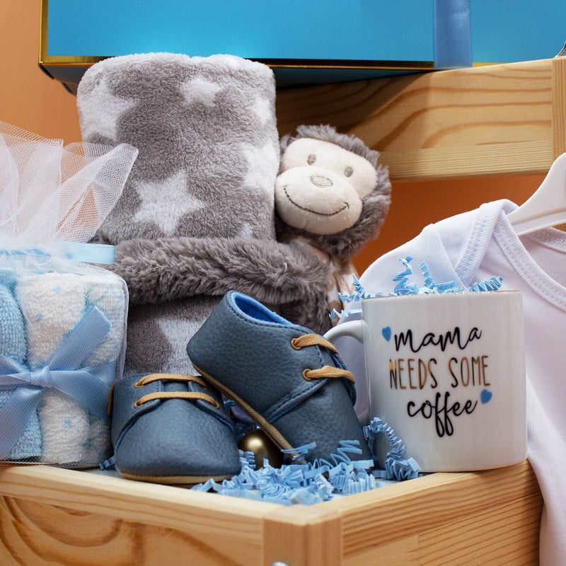 Baby Essential Set in hand-packed box with blanket, plush toy, washcloths, baby shoes, onesie, and mother's mug, suitable for newborns 0-6 months.