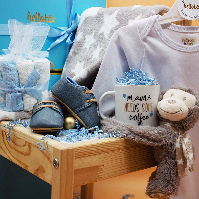 Baby Essential Set with blanket, plush toy, washcloths, moccasins, onesie, and mother's mug in elegant box.