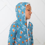 Orange zip-front baby hoodie with hood and kangaroo pocket, printed with a basketball hoops design