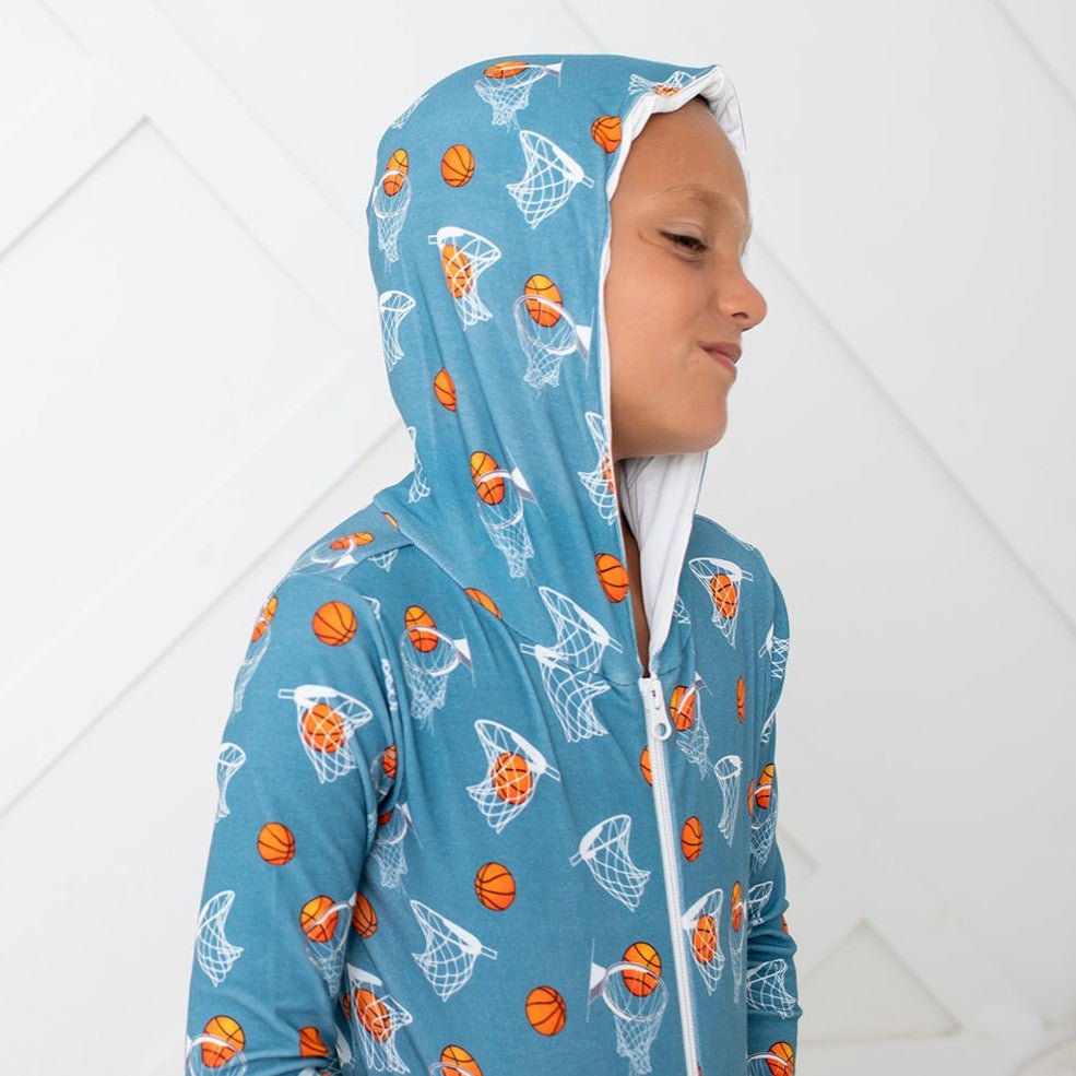 Orange zip-front baby hoodie with hood and kangaroo pocket, printed with a basketball hoops design