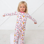 Long-sleeve pajama set with matching pants in a pink owl and floral print, worn by a smiling toddler.