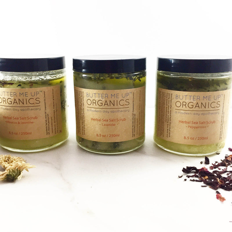 Organic Sea Salt Herbal Scrub jars with eco-friendly packaging on a white background.